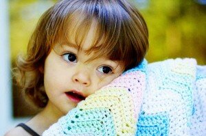 Little girl with crocheted blankie.