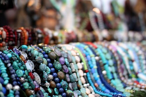 Beaded necklaces on display at a holiday market.